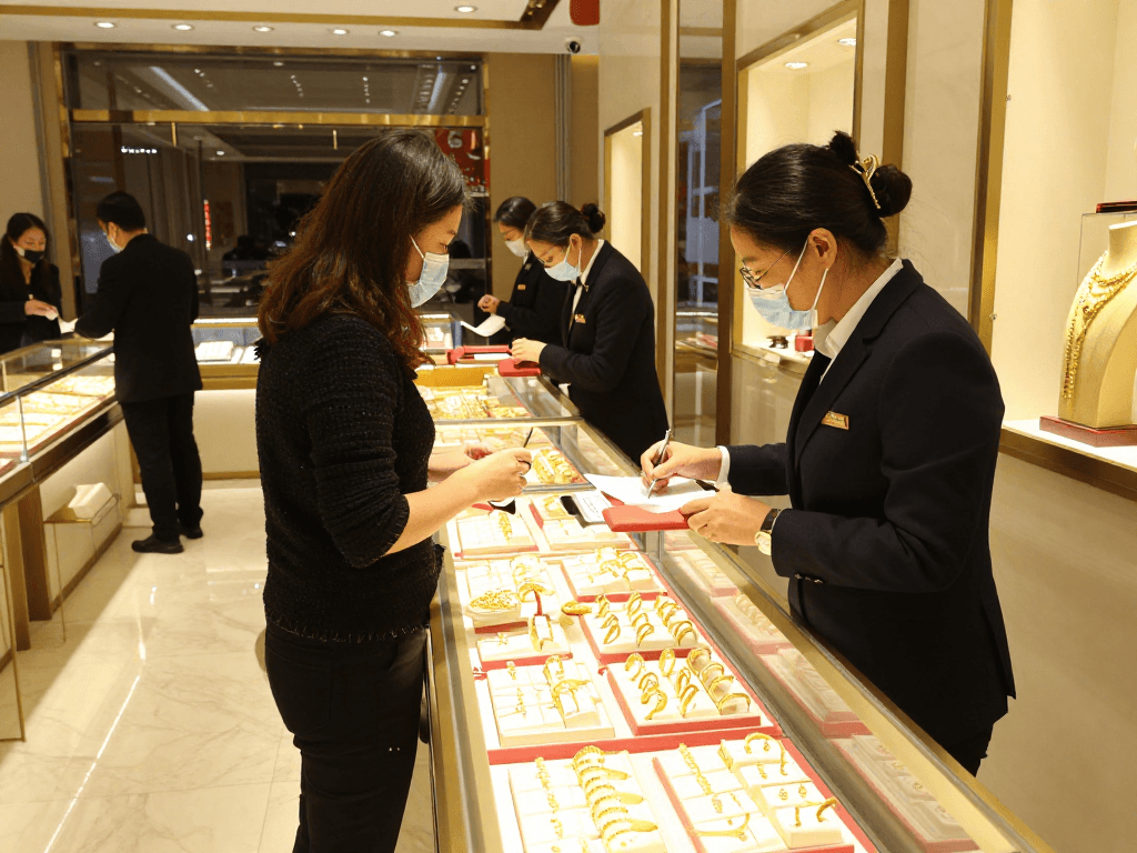 Engaging in mantra88 login process at a gold store, examining luxurious 24K jewelry.